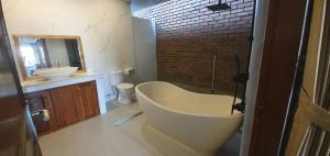 a bathroom with a large bath tub and a sink at Tebanyoman Guesthouse in Dalung