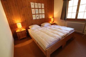 a bedroom with a large bed with two lamps on tables at Les Grands Prés 31 in Chateau-d'Oex