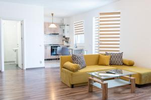 a living room with a yellow couch and a table at Lady-s Place in Floreşti