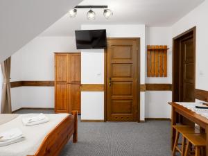 Una habitación con dos camas y un televisor en la pared. en Willa Lichajówka, en Małe Ciche