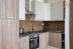 Is-SwieqiにあるSpacious 4BR home with private balcony in Swieqi by 360 Estatesの木製のキャビネットとコンロ付きオーブンを備えたキッチン