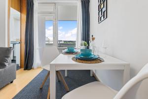 a white dining room with a white table and chairs at Sonniges City-Apartment mit Südbalkon und Parklatz in Neusäß