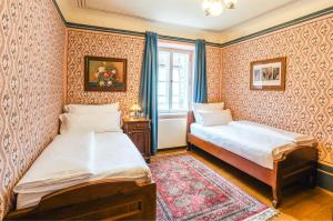 2 letti in una camera con carta da parati di Hotel Latrán a Cesky Krumlov