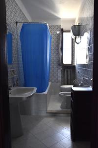 a bathroom with two sinks and a blue shower curtain at VERETO apartaments Lecce in Lecce
