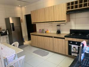 una cucina con mobili in legno e un frigorifero in acciaio inossidabile di Casa de mãe Completa! a Marília
