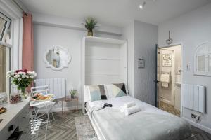 une chambre avec un lit, une table et un miroir dans l'établissement Lunar Stays, à Blackpool