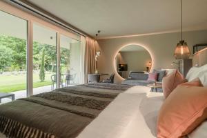 a bedroom with a large bed and a large window at Belia Lofts - ADULTS ONLY - Apartments in Appiano sulla Strada del Vino