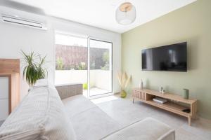 a living room with a couch and a flat screen tv at Villa Romarin in Marignane