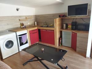a small kitchen with red cabinets and a washing machine at vero tony in Cournonterral