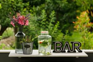 a bottle of water and a vase of flowers on a table at Belia Lofts - ADULTS ONLY - Apartments in Appiano sulla Strada del Vino