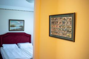 a bedroom with a bed and a picture on the wall at Kiskakas Vendégház in Székkutas