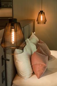 a bedroom with a bed with pillows and two lamps at Belia Lofts - ADULTS ONLY - Apartments in Appiano sulla Strada del Vino