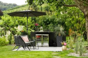 a patio with a table and an umbrella at Belia Lofts - ADULTS ONLY - Apartments in Appiano sulla Strada del Vino