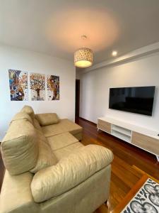 a living room with a couch and a flat screen tv at Apartamento nuevo en Zona Baja de Cotolino in Castro-Urdiales