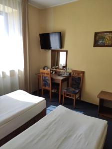 Pokój hotelowy z 2 łóżkami, stołem i lustrem w obiekcie Apart Chopin w Pruszczu Gdańskim