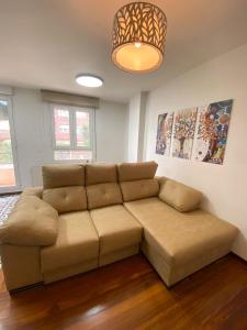 a living room with a brown couch in a room at Apartamento nuevo en Zona Baja de Cotolino in Castro-Urdiales