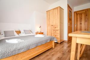 1 dormitorio con cama grande y escritorio de madera en Za górami Za lasami Zakopane, en Zakopane