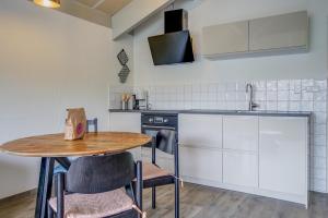 a kitchen with a small table and a sink at Beach Appartement 17 - Aan de duinen, Callantsoog aan Zee in Callantsoog
