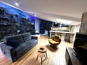 a living room with a couch and a kitchen at Jungle Gite in Fumel