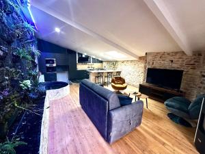 a living room with a couch and a tv at Jungle Gite in Fumel