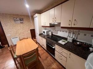 a kitchen with a table and a stove top oven at Villa Marie in Betanzos