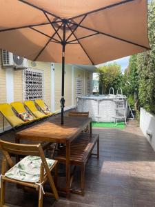 a wooden table and chairs under an umbrella on a patio at Douro Garden & Rooftop Home in Vila Nova de Gaia