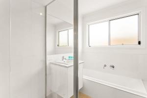 a white bathroom with a shower and a sink at Cozy Beach Bungalow in Cowes in Cowes +17 photos