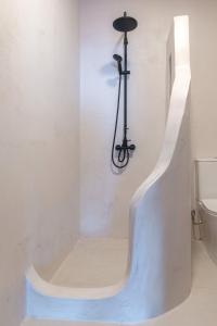 a white bath tub in a bathroom with a toilet at SeaScape Boutique Villa in Achlia
