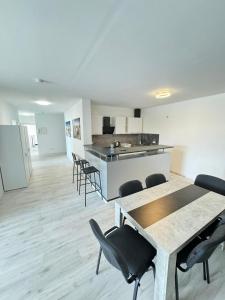 une pièce avec des tables et des chaises et une cuisine dans l'établissement Frühling Apartment, à Bergisch Gladbach