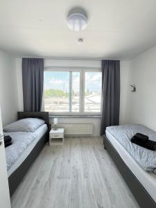 une chambre avec deux lits et une fenêtre dans l'établissement Frühling Apartment, à Bergisch Gladbach
