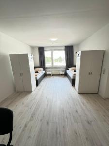une grande chambre avec deux lits et une grande fenêtre dans l'établissement Frühling Apartment, à Bergisch Gladbach 8 autres photos