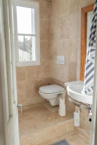 a bathroom with a toilet and a sink and a window at Maison avec piscine in Aix-en-Provence