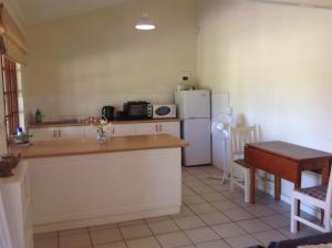 a kitchen with a counter and a refrigerator and a table at La Verdure Fruit Farm in Franschhoek