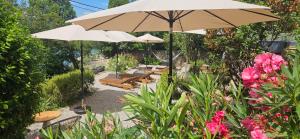 a patio with benches and an umbrella and flowers at Rooms Villa Lucija in Kraljevica