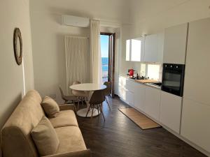 a living room with a couch and a table in a kitchen at North Wind Luxury Home in Vieste