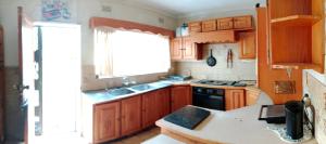 a kitchen with wooden cabinets and a sink and a window at 54 Martjie laan in Brits