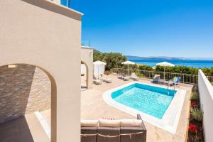 a villa with a swimming pool and the ocean at Villa Alora in Barbati