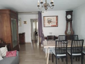 a living room with a table and chairs and a clock at T3 avec piscine et proche de la mer 5mns à pied in Saint-Raphaël