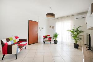 a living room with two chairs and a tv at Mistral Suite Apartment - free private car park in Bari