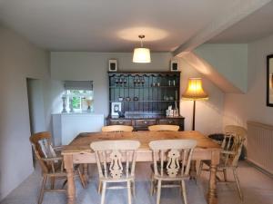 a dining room with a wooden table and chairs at Outrake Cottage in Coniston
