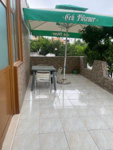 Una mesa y sillas bajo una sombrilla en un patio. en Aulona's Garden, en Vlorë