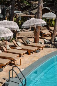 grupa leżaków i parasoli przy basenie w obiekcie Parco Ibiza, by Camping San Antonio est 1961 w mieście San Antonio