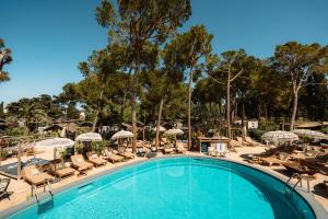 basen z leżakami i parasolami w obiekcie Parco Ibiza, by Camping San Antonio est 1961 w mieście San Antonio