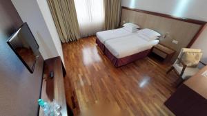 a hotel room with a bed and a flat screen tv at City5 ROOMS & SUITES by LSA in Skopje +20 photos