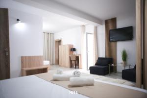 a bedroom with a bed and a living room with a couch at Hotel San Međugorje in Čitluk