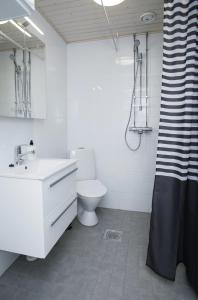 a white bathroom with a toilet and a sink at Forenom Serviced Apartments Vantaa Korso in Vantaa