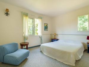 ein Schlafzimmer mit einem Bett und einem Stuhl und Fenstern in der Unterkunft Spacieuse Villa à Crac'h : 4 Ch. pour 8 Pers., Beau Jardin, Proche Plages et WiFi - FR-1-477-244 in Crach