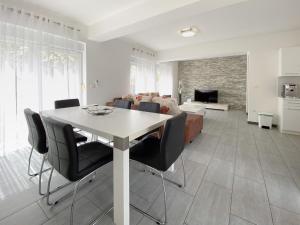 un salon avec une table et des chaises blanches dans l'établissement Villa Lara II with private pool, à Ližnjan