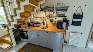 a kitchen with a sink and a staircase at Vila Vynuogyne in Paberžė