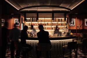 a group of people sitting at a bar at Pomme d'Or Hotel in Saint Helier Jersey